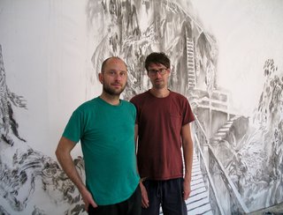 Jim Holyoak (left) and Matt Shane pose as they work on their drawing installation, "Forestrial Brain" at Open Space in Victoria. Photo by Portia Priegert.