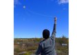 Flying a boulder kite at a 2018 workshop hosted by the Museum of the Flat Earth on Fogo Island, Nfld.