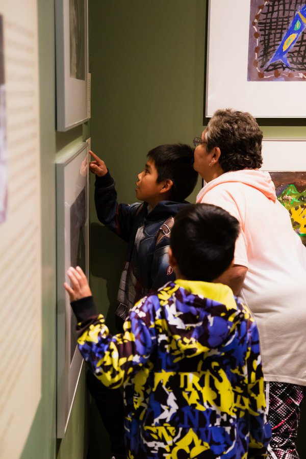 Family members of a residential school survivor look at drawings in "There is Truth Here" at the Museum of Vancouver.