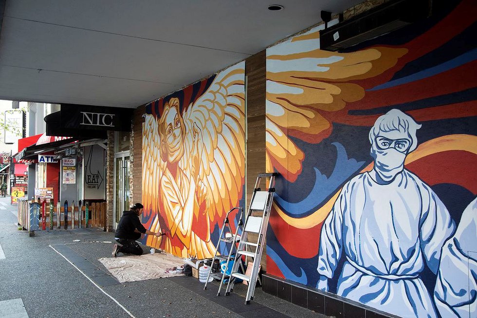 Artist Will Phillips at work on a Vancouver mural that pays tribute to medical workers. (photo by Gabriel Martins)