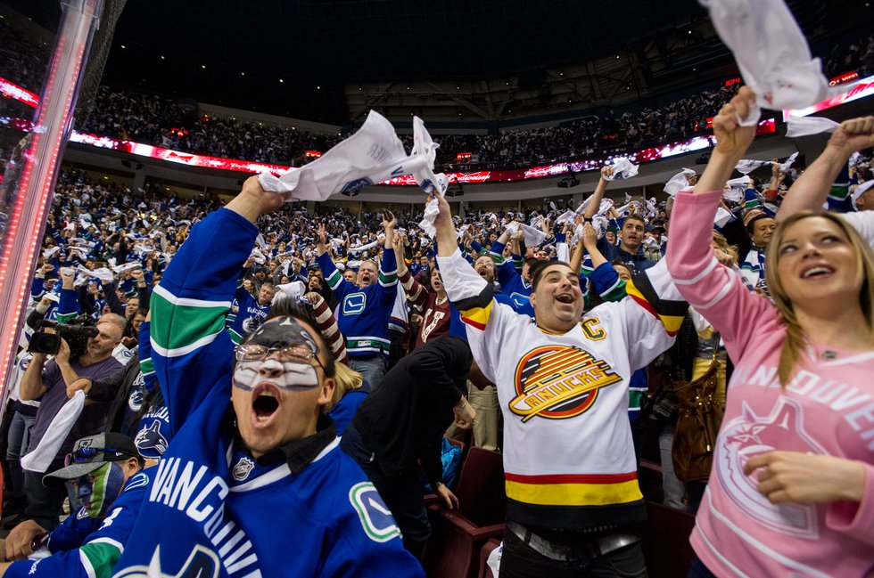 Vancouver Canucks fans go crazy after their team scores against the Calgary Flames during the second period of Game 1