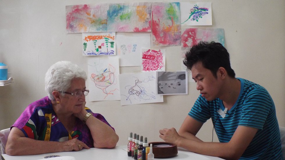 Art therapist Lucille Proulx (left) works with a client in Thailand. (photo used with client's permission, courtesy Canadian International Institute of Art Therapy)