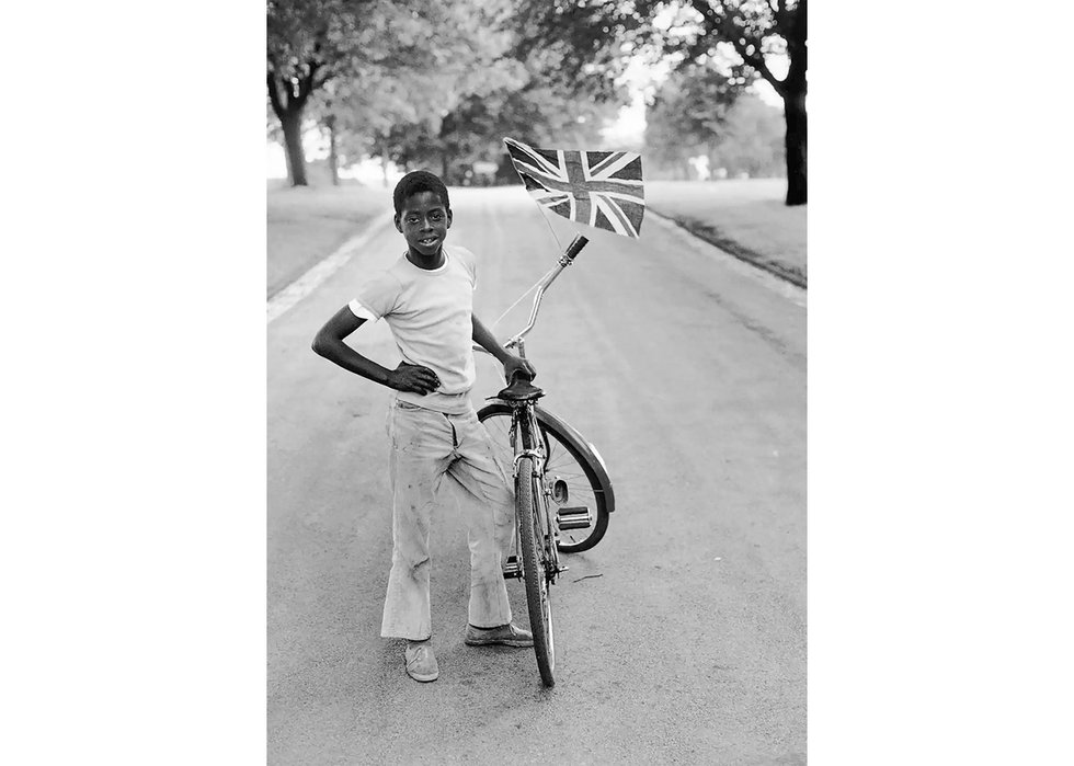Vanley Burke, "Boy with Flag, Winford, in Handsworth Park," 1970, from "As We Rise: Photography from the Black Atlantic" (Aperture, 2021) © Vanley Burke