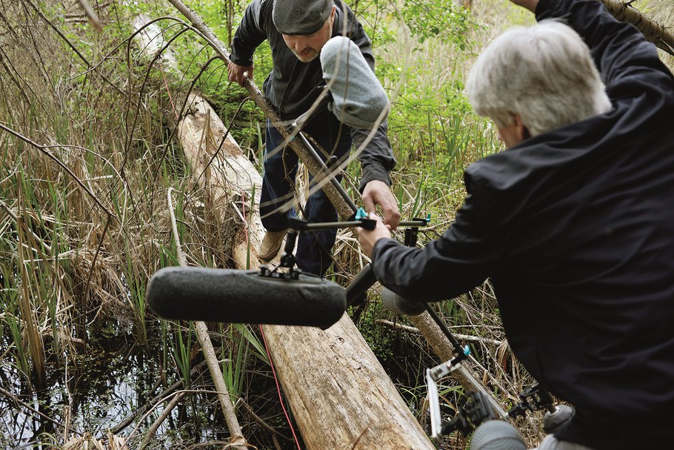 Mark Timmings works with recording engineer Eric Lamontagne to place microphones on a fallen tree at the centre of the ṮEḴTEḴSEN wetland on April 25