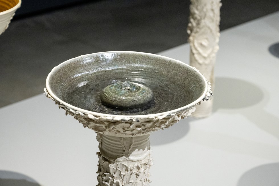 Installation view, Emmanuel Osahor, “Birdbath,” 2023, ceramic, water, and electronic motor, 25" x 14" x 14" (courtesy of the artist and Galerie Nicolas Robert; photo by Charles Cousins, courtesy of Art Gallery of Alberta)