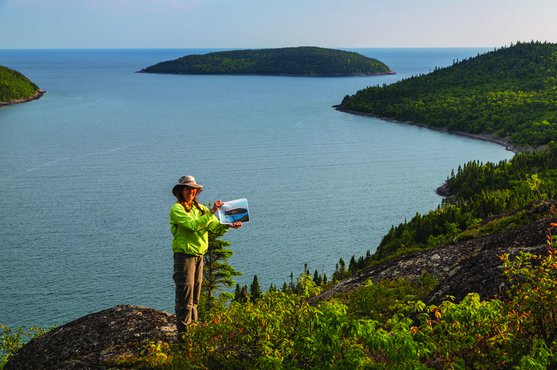 Joanie McGuffin holds a copy of a Lawren Harris painting, "Island Lake Superior"